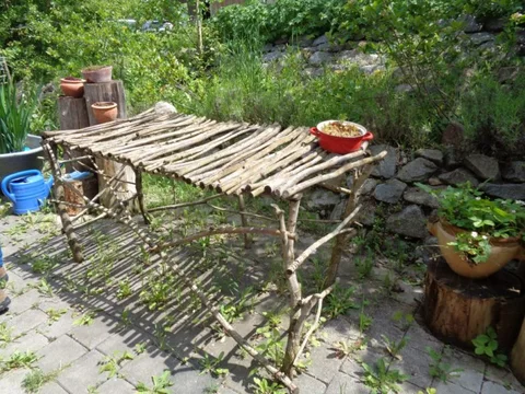 Sitzplatz mit Tisch und Topfpflanzen im Mienbacher Waldgarten