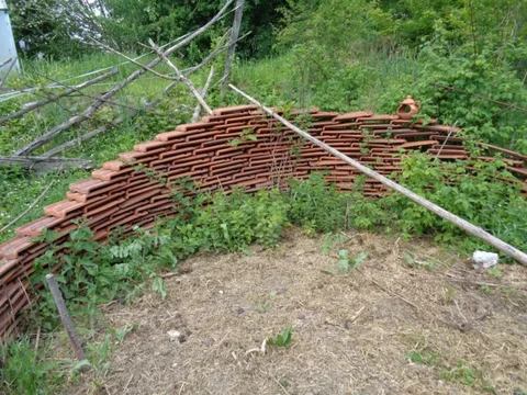 Rundes Gartenbeet mit natürlichen Ästen als Struktur