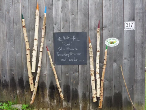 Alte Fliesenmustertafel schwarz gestrichen und als Gartenschild weiterverwendet