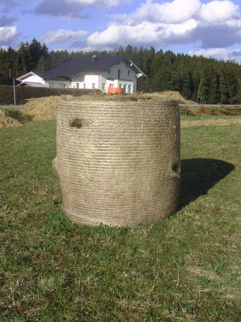 Großer runder Heuballen im Frühjahr vor dem Pflanzen der Kürbisse