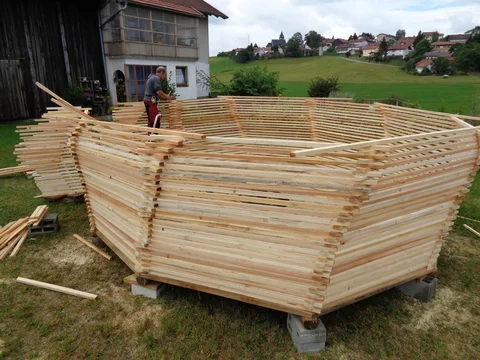 Arbeiten mit Leiter am hohen Gartenpavillon aus Holz