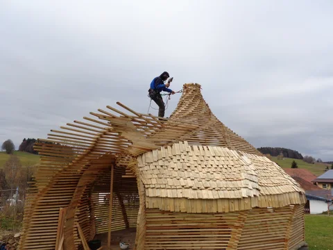 Arbeiten auf dem Holzschindeldach des Gartenpavillons