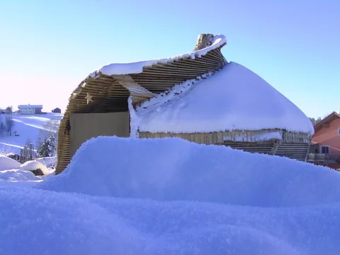 Schnee auf dem geschwungenen Dach des Gartenpavillons