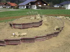 Kräuterspirale mit alten Dachziegeln als Einfassung