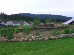 Bepflanzte Kräuterspirale mit beschrifteten Kräutern
